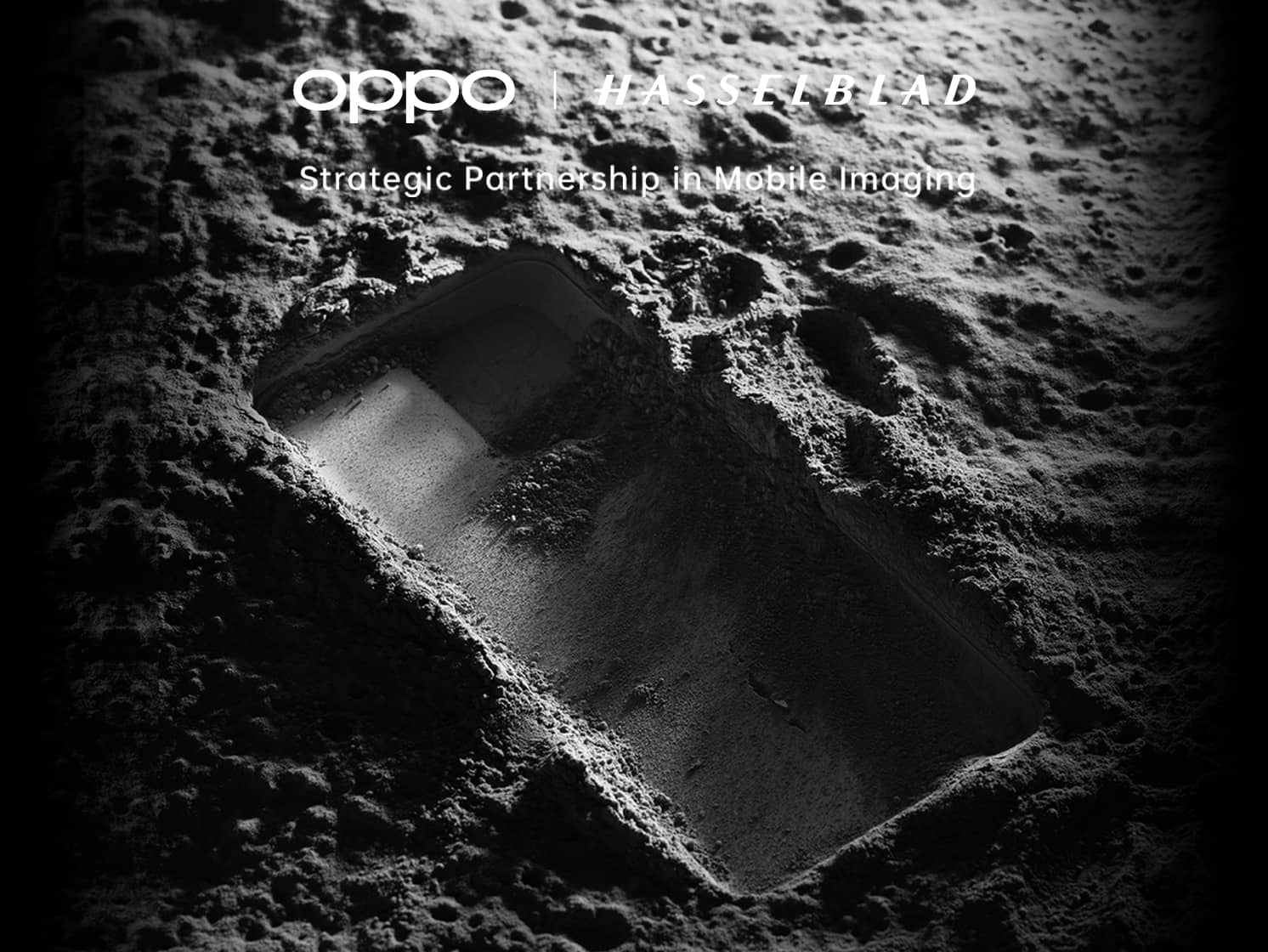 Black and white picture of a phone shaped indent on what is meant to be the moon with OPPO and Hasselblad branding in white text above the image